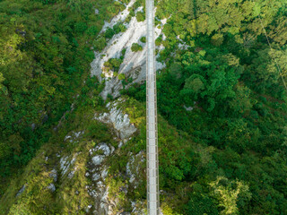 Wall Mural - Aerial view of a Tibetan suspended bridge in Nepal is a primitive type of bridge in which the deck lies on two parallel load-bearing cables that are anchored at either end. Wild nature