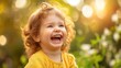 Cheerful little toddler or little curly child laughing on bright background