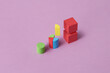 © Yaroslav Danylchenko/Stocksy - Wooden blocks of geometric shapes levitating over violet background