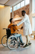 © BONNINSTUDIO/Stocksy - Doctor and man in wheelchair greeting each other at hospital