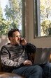 © Eloisa Ramos/Stocksy - mature man working with laptop and calling by smartphone
