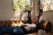© Eloisa Ramos/Stocksy - man yawning and stretching on sofa