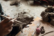 © Demetr White/Stocksy - man makes holes in clay