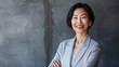 Happy asian american businesswoman, company leader CEO boss executive standing in front of company building. Portrait of a young vietnamese woman isolated on gray wall background.