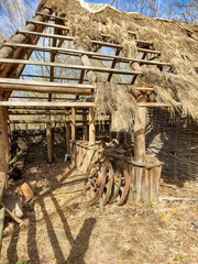 Wall Mural - Old wooden houses with a thatched roof. Early spring landscape.