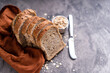 Sliced whole grain loaf bread on dark rustic wooden background