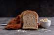 Sliced whole grain loaf bread on dark rustic wooden background