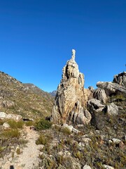 Canvas Print - a rock on a trail with grass and shrubs next to it