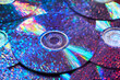 © Yaroslav Danylchenko/Stocksy - Trendy pattern of CD discs with iridescent light and water droplets