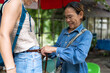 © Alvaro Lavin/Stocksy - Saleswoman trying a belt on a customer.