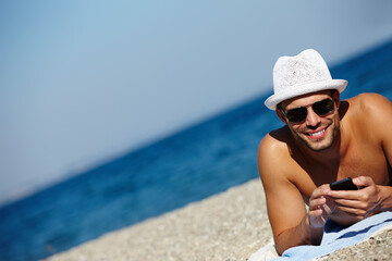 Man, beach and smartphone in portrait on holiday with ocean on seashore with blue sky in summer for peace. Male person, vacation and relax with phone for memories in cancun with wellness on trip