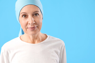 Wall Mural - Mature woman after chemotherapy on blue background, closeup