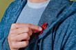 © Juan Moyano/Stocksy - man pinning a red ribbon in his lapel