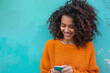 © Centric  - Joyful Curly-Haired Woman Texting on Smartphone