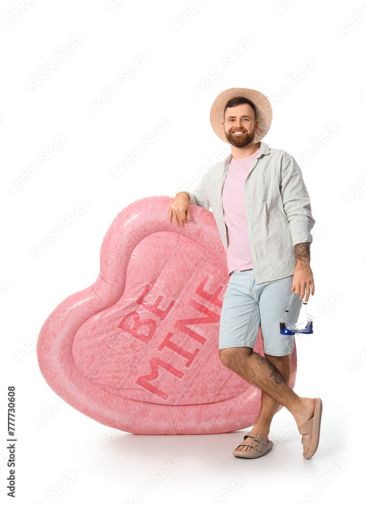 Young man with inflatable mattress and goggles on white background