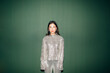 © Studio Firma/Stocksy - Woman posing in front of green wall