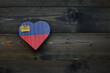 wooden heart with national flag of liechtenstein on the wooden background.
