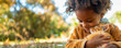 Close up shot Young black girl baby gently holding a cat in her arms in a garden in nature, both looking at each other with tenderness and curiosity. Playing with pets. Banner. Copy space