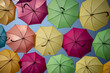 Somewhat abstract image of the bottom of a sequence of umbrellas.