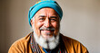 A man with a beard and a turban on his head, smiling and looking directly at the camera.