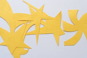 Wall Mural - layered or randomly overlapping abstract yellow paper stars with tails on textured paper