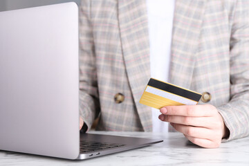 Canvas Print - Online payment. Woman with laptop and credit card at white marble table, closeup