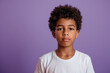 Determined young Hispanic African boy on violet background