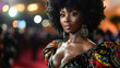 A stunning black woman stands confidently on the red carpet her hair styled in a fierce afro and her outfit a bold mix of vibrant colors and patterns. Her dress features a plunging .