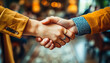 © Na-No Photos - Two people in long-sleeve shirts are shaking hands in a warmly lit, bokeh-blurred background, indicating a friendly or formal interaction.