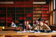 © Studio Firma/Stocksy - Students in library studying together