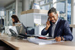 © Jovo Jovanovic/Stocksy - Smiling professional analyzing reports while talking on smart phone