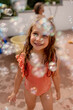 © Stephanie Tamir/Stocksy - A girl standing with a lots of bubble soap around