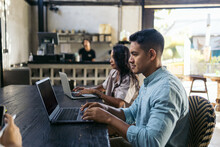 People Working Online In A Modern Coffee Shop