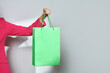 © Marc Tran/Stocksy - Cropped view of trendy woman holding shopping bags on white background