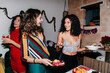 © Lucas Ottone/Stocksy - Friends serving food at a dinner party