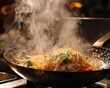 Steam rising from a hot wok as Pad Thai is tossed