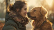 A tender moment between a smiling woman and a golden retriever in soft sunlight.
