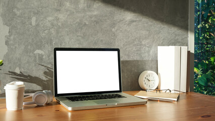 Wall Mural - Laptop with white blank screen, books, coffee cup and headphone on wooden table.