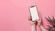  adult holding smart phone with pink nail polish showing digital display,Girl hand holding smartphone on pink background in studio. Mobile phone mockup for your product.