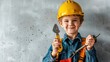 Young child dressed as a construction worker with a hard hat, holding a wrench and a screwdriver, smiling proudly.