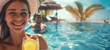 Joyful tanned woman in a hat with flowing hair and a cocktail smiles in the pool of a beautiful resort on a sunny day. Banner with copy space