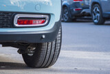 Fototapeta Natura - Close-up of car tires and wheel parked on asphalt roads.