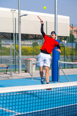 Man jumping to reach the ball in a pickleball court