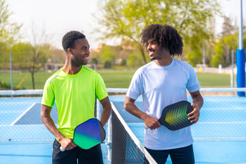 Friends smiling standing in a pickleball court