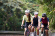 three happy young asian adults riding bike on rural road