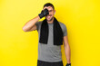 Young sport caucasian man isolated on yellow background covering eyes by hands and smiling