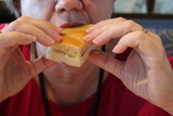 Fototapeta Storczyk - Donna che mangia un tramezzino