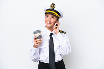 Wall Mural - Airplane caucasian pilot woman isolated on white background holding coffee to take away and a mobile