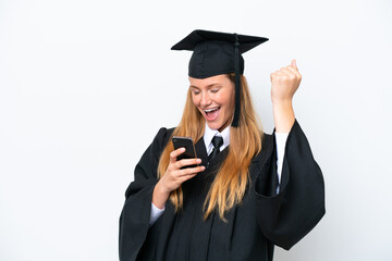 Wall Mural - Young university graduate caucasian woman isolated on white background with phone in victory position