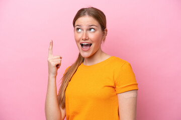 Wall Mural - Young caucasian woman wearing band aid isolated on pink background intending to realizes the solution while lifting a finger up